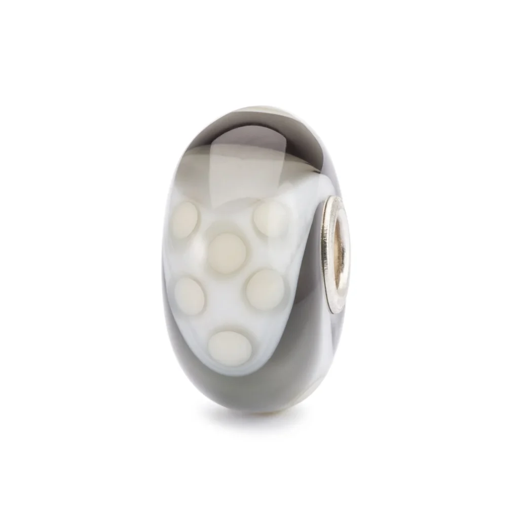 Bead Trollbeads Armadillo Fantasia in vetro con motivo a pois bianchi su fondo grigio sfumato.