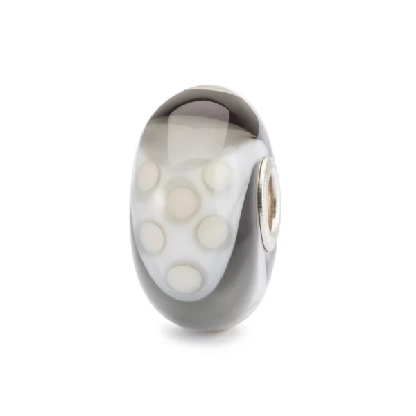 Bead Trollbeads Armadillo Fantasia in vetro con motivo a pois bianchi su fondo grigio sfumato.