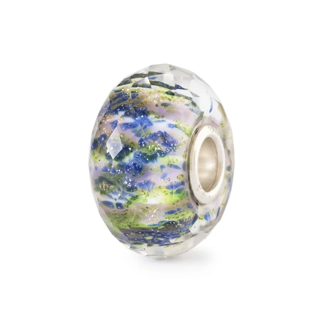 Bead Trollbeads Sussurro di Rugiada in vetro sfaccettato con inclusioni scintillanti e sfumature blu, viola e verde acido.