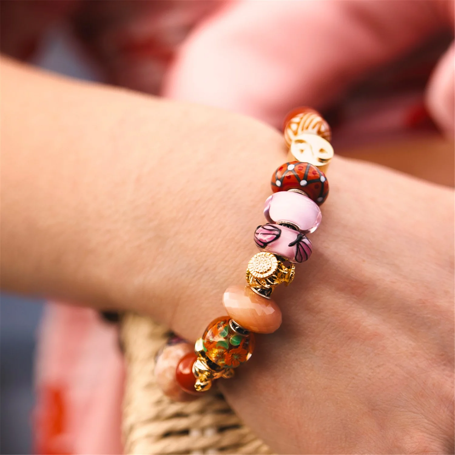Bead in vetro Anima dei fiori Trollbeads TGLBE-30196 con decorazioni floreali interne arancioni e verdi e inserto centrale in argento 925.