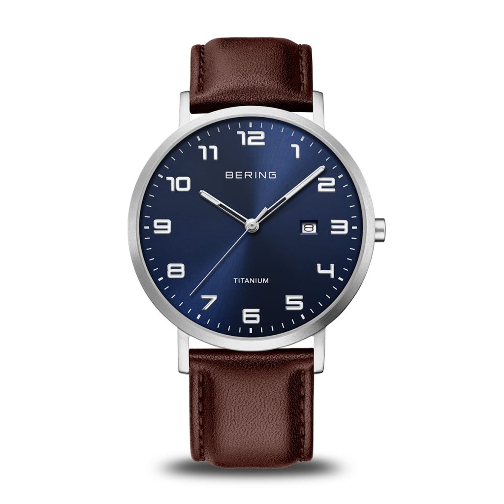 Orologio solo tempo Bering 18640-505 con cassa rotonda in titanio, quadrante blu soleil, datario e cinturino in pelle marrone scuro.