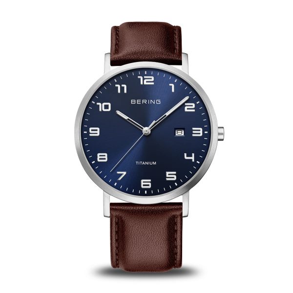 Orologio solo tempo Bering 18640-505 con cassa rotonda in titanio, quadrante blu soleil, datario e cinturino in pelle marrone scuro.