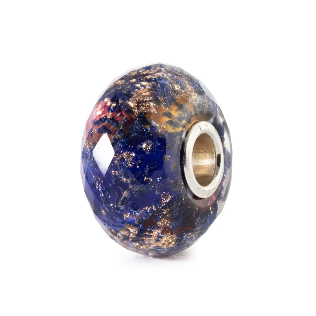 Bead Serata Estiva Trollbeads TGLBE-30223 People's Bead 2026 in vetro sfaccettato blu con dettagli dorati.
